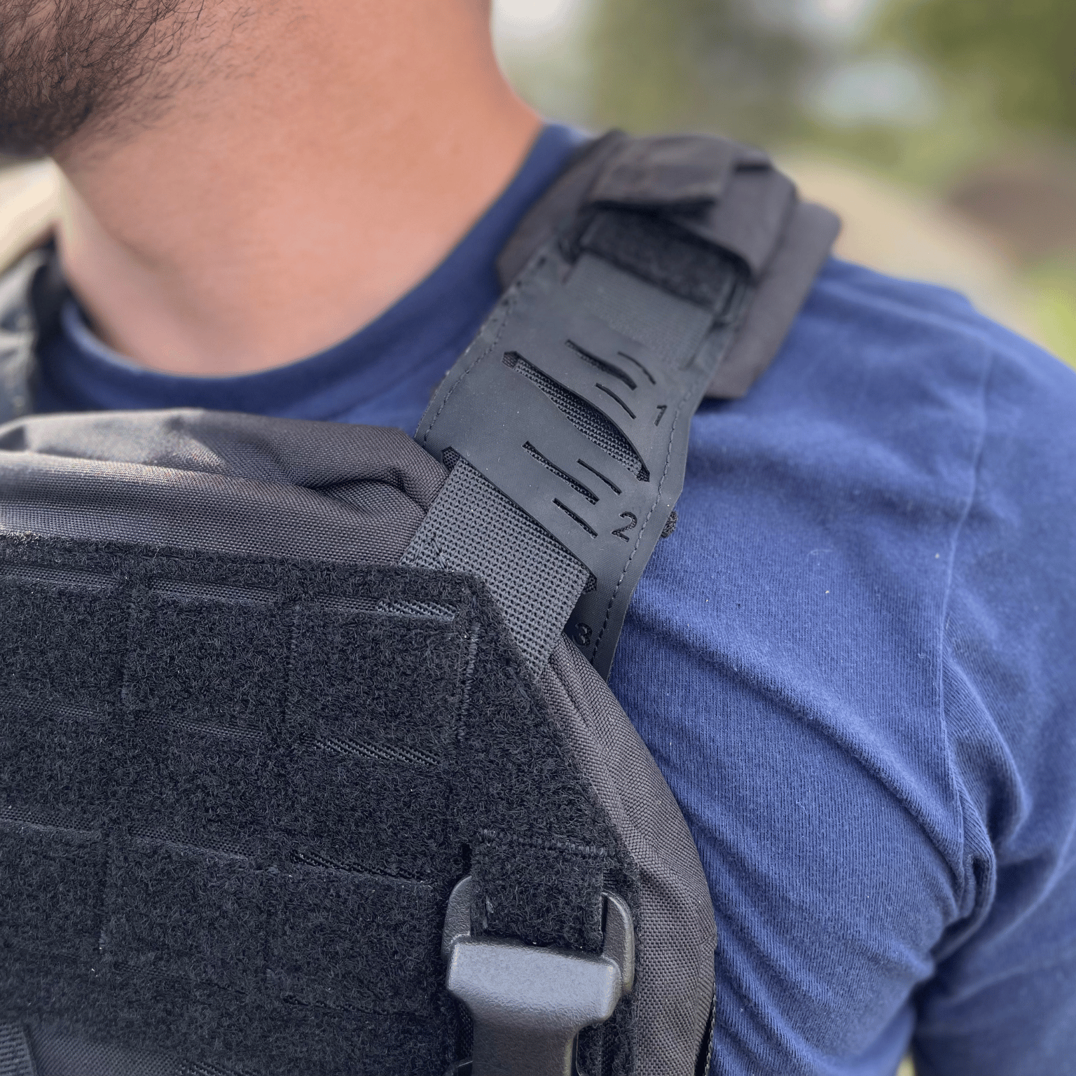 Close up showing stitching and detail of black plate carrier straps.